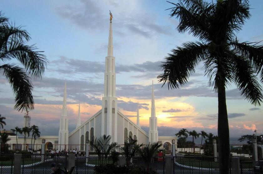 The Manila Philippines Temple, a white building with two large central spires at the front and back with four smaller spires at their sides.