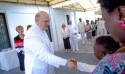 Elder Dale G. Renlund of The Quorum of the Twelve Apostles greets a young Latter-day Saint during the cornerstone ceremony of the Kinshasa DR Congo Temple.