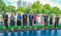 A row of people in Sunday best holding ceremonial golden shovels and smiling at the camera.