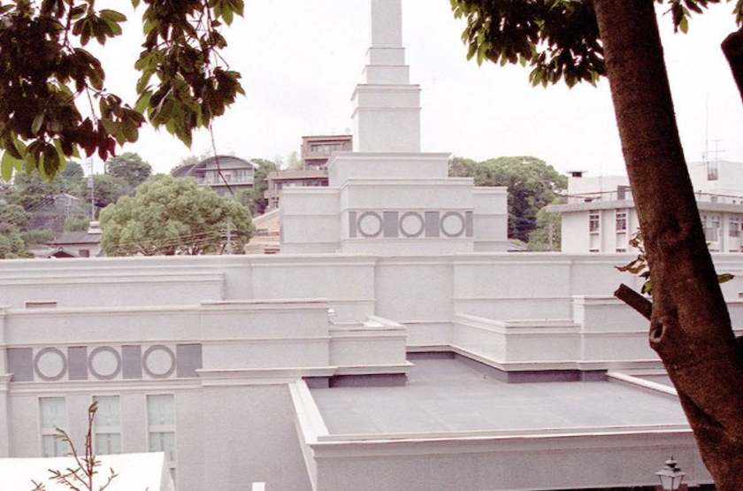 The top of the Fukuoka Japan Temple, showing the spire atop a white, layered structure.