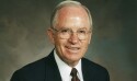 Elder John K. Carmack wearing a black suit and red tie.