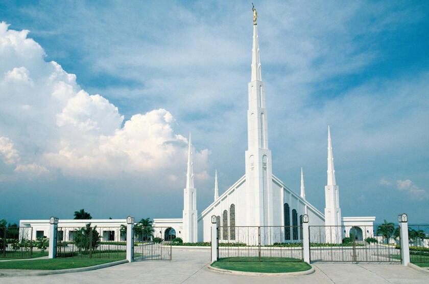 The Manila Philippines Temple, a white building with two large central spires at the front and back with four smaller spires at their sides.