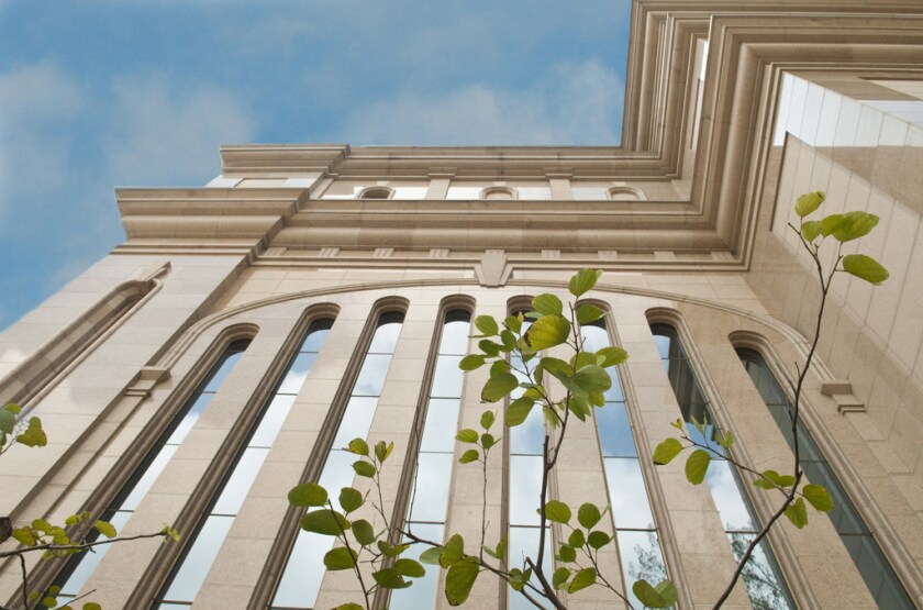 An exterior wall of the Hong Kong China Temple, with a row of thin, vertical windows, from the base looking upward.